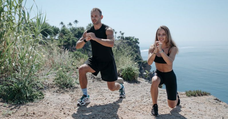 Stretching Exercises - A Man and Woman Working Out Near the Cliff