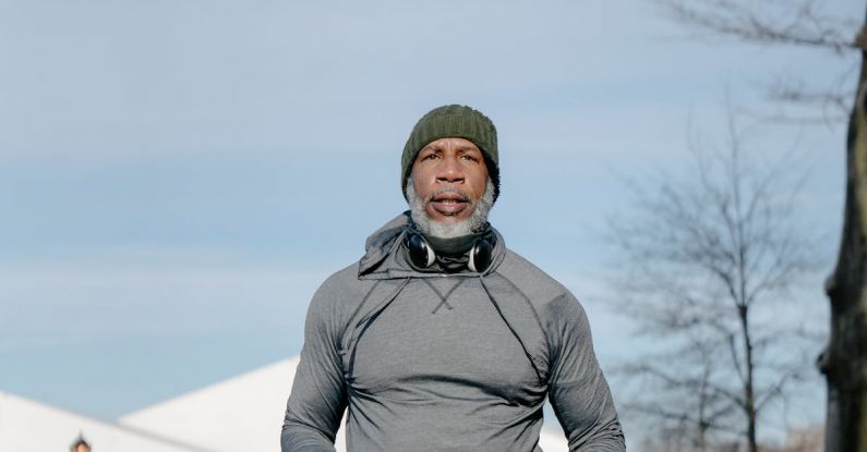 Winter Fitness - Mature Man with a Gray Beard Running in City