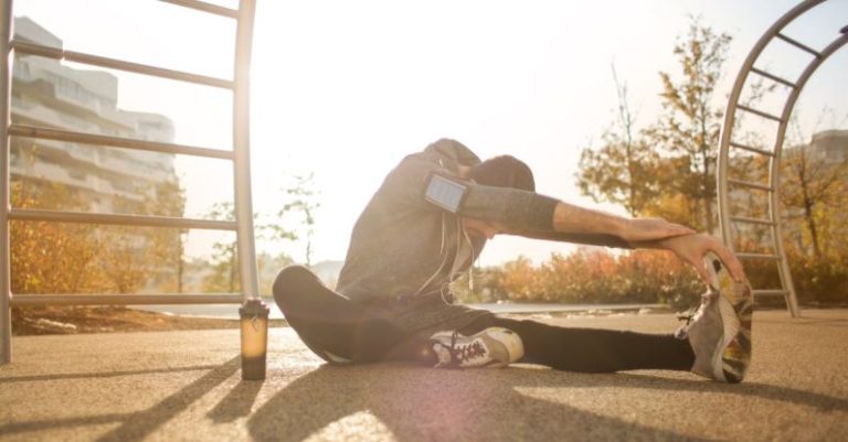 Fall Fitness - Flexible sportsman stretching on sports ground