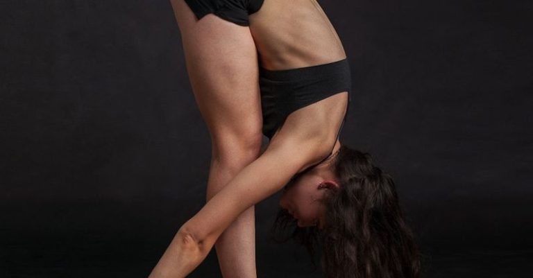 Flexibility - Woman Wearing Black Sports Bra Reaching Floor While Standing