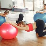 Prenatal Yoga - Pregnancy group practicing with fit ball in fitness class
