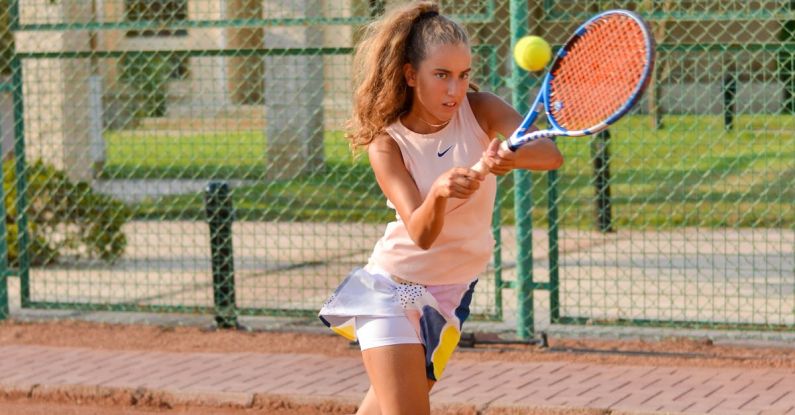 HIIT - Sporty female playing tennis on court