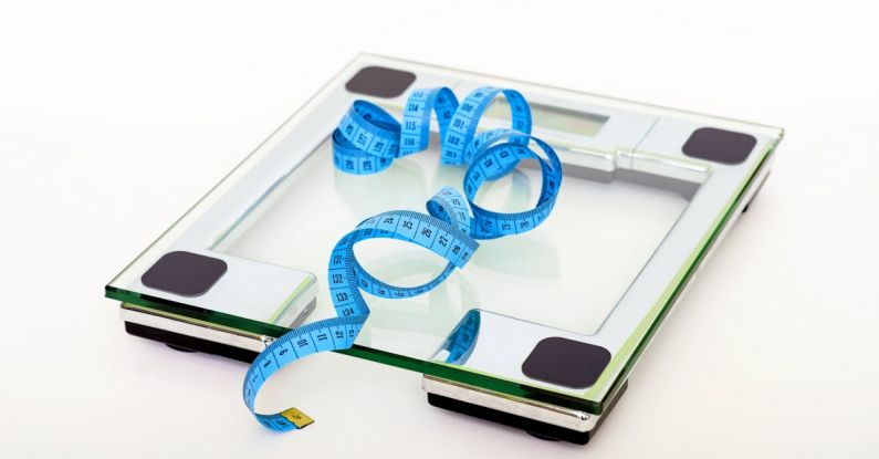 Weight Loss - Blue Tape Measuring on Clear Glass Square Weighing Scale